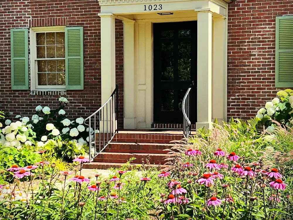 A brick home framed by a designed and installed garden