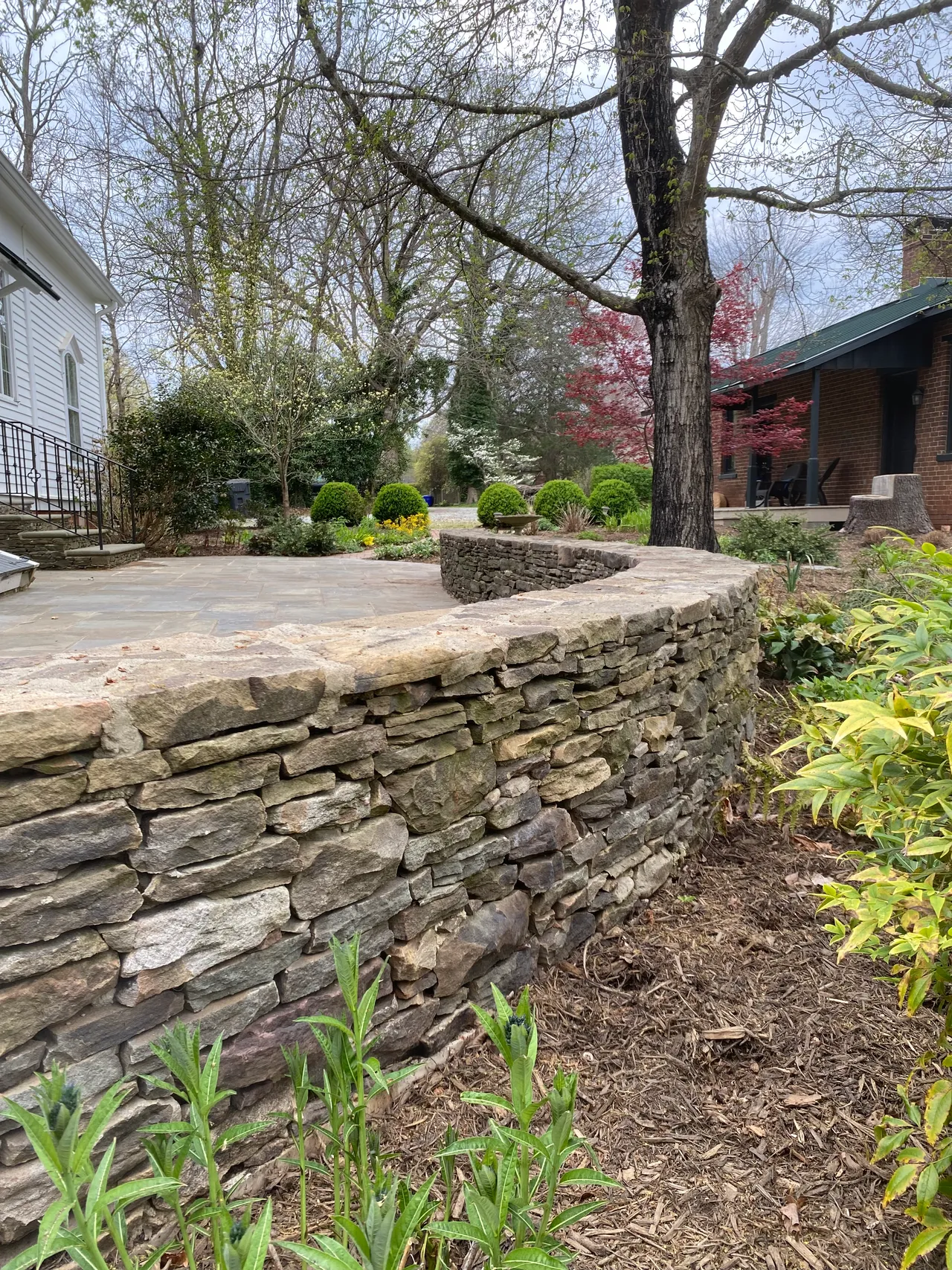 Dry-stack stone wall lining the flagstone path